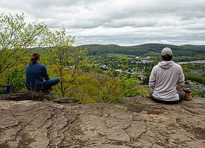 Hartwick College students at top of Table Rock Trail meditating over valley view